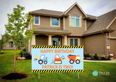 boys construction birthday banner in yellow, orange and blue in front of house