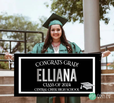 A black and white graduation sign with the text &#39;Congrats Grad! Grads Name, class of 2025 and grads High School&#39; in silver lettering. A silver graduation cap icon is in the bottom right corner.