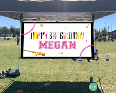 girls softball birthday banner under a pop up tent at sports field