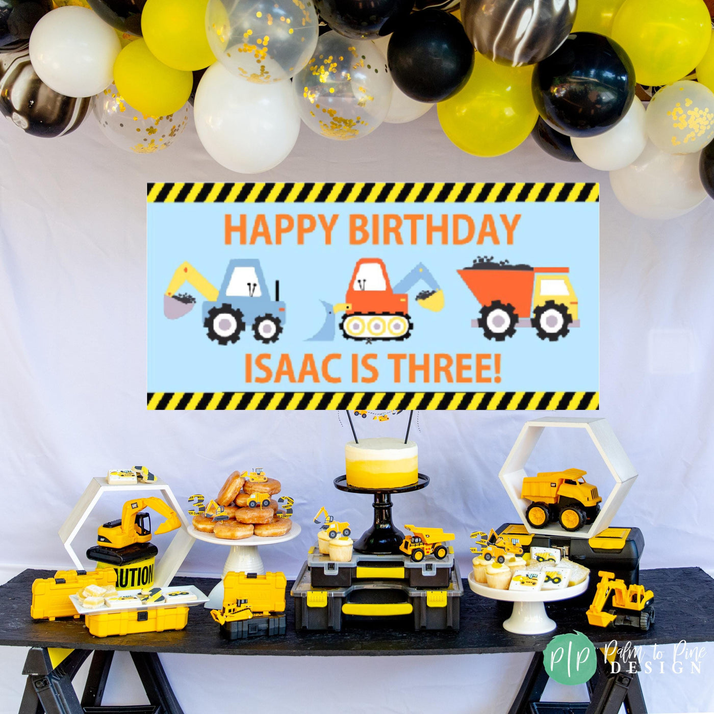 construction birthday dessert table and personalized banner with balloon garland