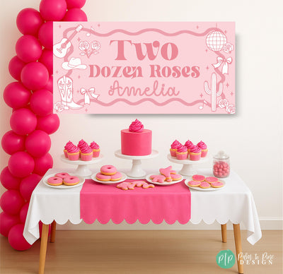 Two Dozen Roses party banner in front of pink dessert table
